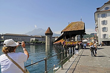 Tourists taking pictures, Kapellbruecke, Chapel Bridge, water tower, Reuss River, historic district, Lucerne, Switzerland, Europe