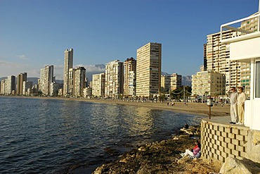 Tourists looking out on the beach of Benidorm, Playa de Levante, Costa Blanca, Spain