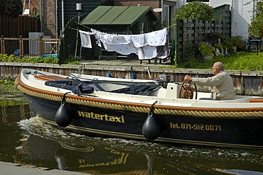 Water cap with driver in a canal, with hung up clothes in the background, Leiden, South Holland, Holland, The Netherlands