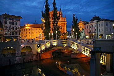 The triple bridge or three bridges crossing the river Ljubljanica to the Preseren square, and the Franciscan church in the back, Ljubljana, Slovenia