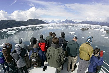 Tourist on a boat look amazed at the icebergs of the Columbia glacier Prince Williams Sound Alaska USA