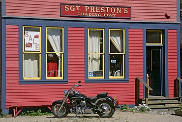 A motorbike in front of a historical wooden building in the gold rush town of Skagway Alaska USA