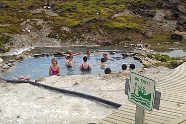 A relaxing bath in the 40 centigrade warm waters of the hot spring in Hveravellir the sign is related to another hot spring Iceland