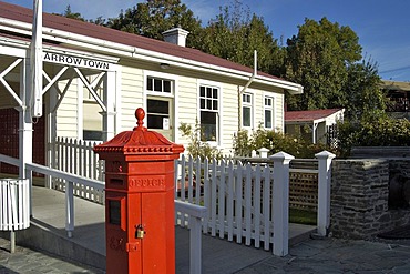 Red letter box and an old historical building of the former gold rush town, Arrowtown, South Island, New Zealand