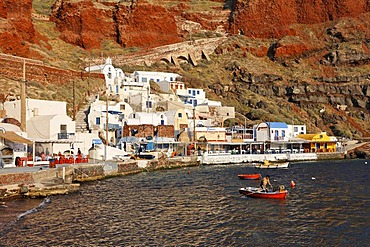 A fishermen in his small rowing boat, harbour of Ammoudi, Oia, Santorini, Greece