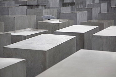 Umbrella amid the stelae or concrete slabs of the Memorial to the Murdered Jews of Europe, Holocaust Memorial, Berlin, Germany, Europe