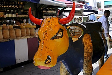 Art object cow in the victualers market, behind it a cheesestand, Munich, Bavaria, Germany, Europe