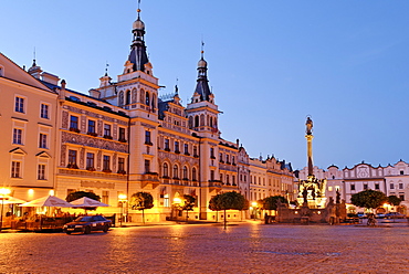 Ornate facade of buildings under streetlights at twilight surrounding the cobbled town square in the historic centre of Pardubice, Pardubice, East Bohemia, Czech Republic, Czechia, Europe