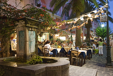 Fountain, restaurant in an alley in the historic centre at dusk, Ischia Ponte, Ischia Island, Campania, South Italy, Europe