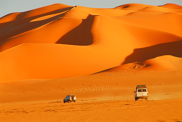 Jeeps in front of sand dunes, Murzuq desert, Libya