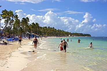 Tourists on a beach lined with palm trees, Punta Cana, Dominican Republic, Caribbean