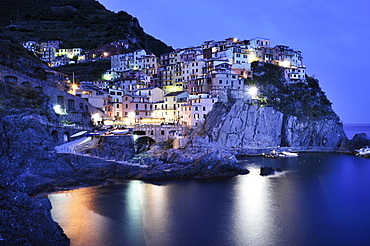 Village of Manarola nestled atop steep coastline at dusk, Liguria, Cinque Terre, Italy, Europe