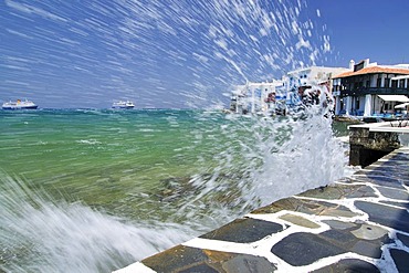 Wave crashing on the promenade along the port of Little Venice, Mykonos Island, Cyclades, Greece, Europe