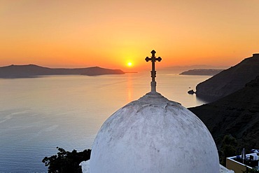 Dome of a church with a cross in front of the sea at sunset, Thira, Fira, Santorini, Cyclades, Greece, Europe
