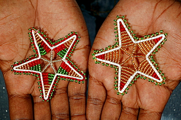 Hands with Christmas stars made of glass beads, Cape Town, South Africa