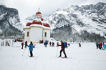 St. Bartholomew's Church at the frozen Koenigssee, cross-country skiers, Berchtesgadener Land, Upper Bavaria, Germany