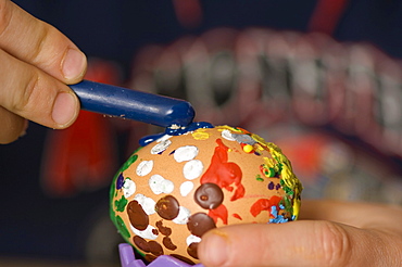 Child painting an Easter egg