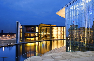 German Bundestag building reflected in the facade of the Marie Elisabeth Lueders House and Paul Loebe House on the opposite side of the Spree River in the evening, Berlin, Germany