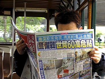 Reading man in tramway, Hongkong, China, Asia