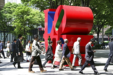 People on their way to work walking by Love-sculpture by American artist Robert Indiana, Shinjuku district, Tokyo, Japan, Asia