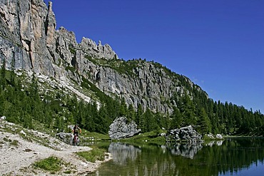 Female mountain biker at Lago di Federa, Dolomites, Italy