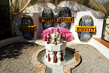 Lip sofa, Pirelli advertising banner and liquor bottle fountain in the garden at the former home of surrealist painter Salvador Dali and his wife Gala in Port Lligat, Province Girona, Spain