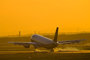 An AEROPLANE starts in the evening light from the Rhein-Main-Airport, Frankfurt, Hessen, Germany.