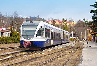 Electric Tatra train at the Tatranska Lomnica train station and the Grand Hotel Praha (back), Slovakia