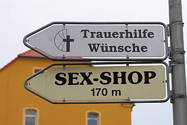 Signposts mourning help and sex shop