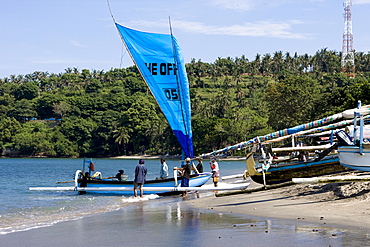 Fisherman returning to shore from fishing with the sail open on his outrigger boat, Lombok Island, Lesser Sunda Islands, Indonesia