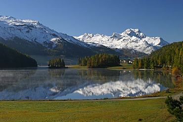 Fall in the engadine. The mountaintops are already snow covered while the engadin lakes are still reflecting the mountain scene.