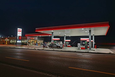 DRI of an Avia gas station illuminating a wide road at dusk