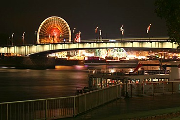 Deutzer bridge over the Rhine river and fair lights with the big wheel in Cologne, NRW, Germany