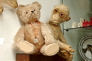 Two old, worn stuffed animals (teddy bear and monkey plush toy) at an antiques shop in Nuremburg, Middle Franconia, Bavaria, Germany, Europe