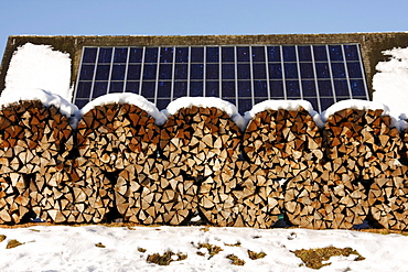 Solar panels and stacked firewood in wintertime near Schluchsee (Schluch Lake), Black Forest, Baden-Wuerttemberg, Germany, Europe