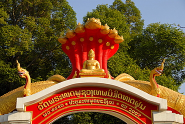 Entrance gate to the buddhist monastery Wat That Fune, decorated with golden snakes, Nagas, Vientiane, Laos, Asia