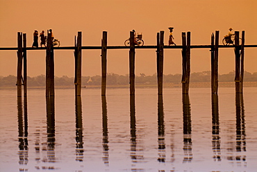 Cyclists and pedestrians crossing the U Bein Bridge at sunset, old wooden teak bridge, Mandalay, Myanmar, Southeast Asia