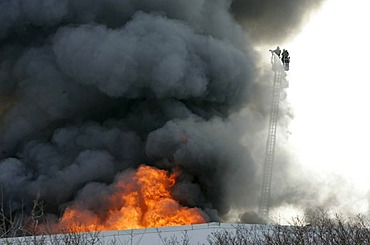 German fire brigade men fights a blaze in a warehouse in Munich Bavaria Germany.