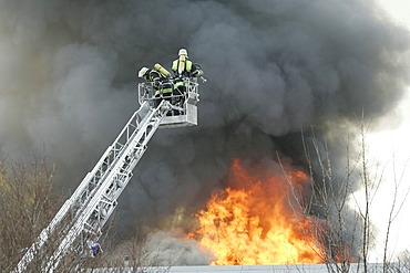 German fire brigade men fights a blaze in a warehouse in Munich Bavaria Germany.