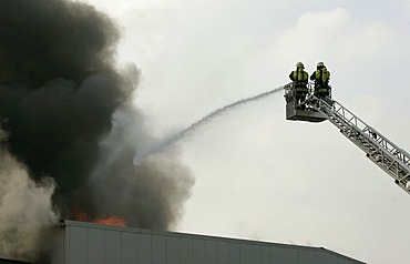 German fire brigade men fights a blaze in a warehouse in Munich Bavaria Germany.