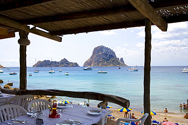 Beach restaurant in the bay of Cala dÂ¥Hort, view of rock island Es Vedra, Ibiza, Balearic Islands, Spain, Europe