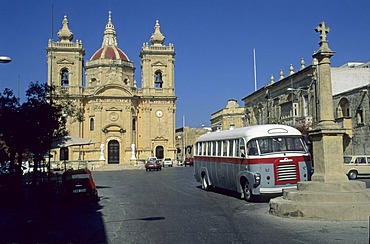 Old bus in front of the church of Nadur, Gozo Island, Malta