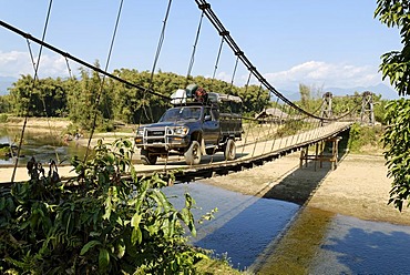 Fourwheeldrive vehicle driving over a suspension bridge, Kachin State, Myanmar