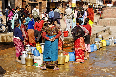 Woman gets drinking water in the old town of Bhaktapur, Kathmandu, Nepal