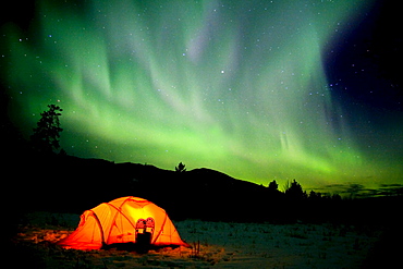 Tent with snowshoes, Northern Lights (Aurora borealis) overhead, Yukon Territory, Canada, North America