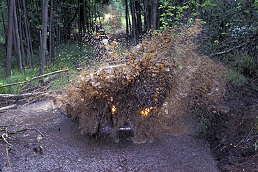 Offroad vehicle is driving with speed into water