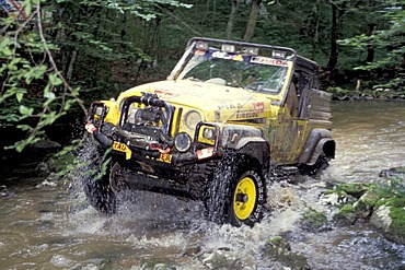 Offroad vehicle is driving in riverbed