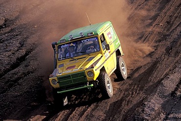 Offroad vehicle is driving downhill on a gravel road