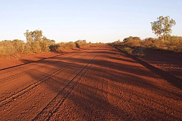 Straight gravel road in Pilbara outback at sunset western australia WA