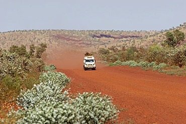 Toyota Landcruiser FJ 75 Arkana safari car driving on a red road in Karijini National Park Pilbara region western australia WA